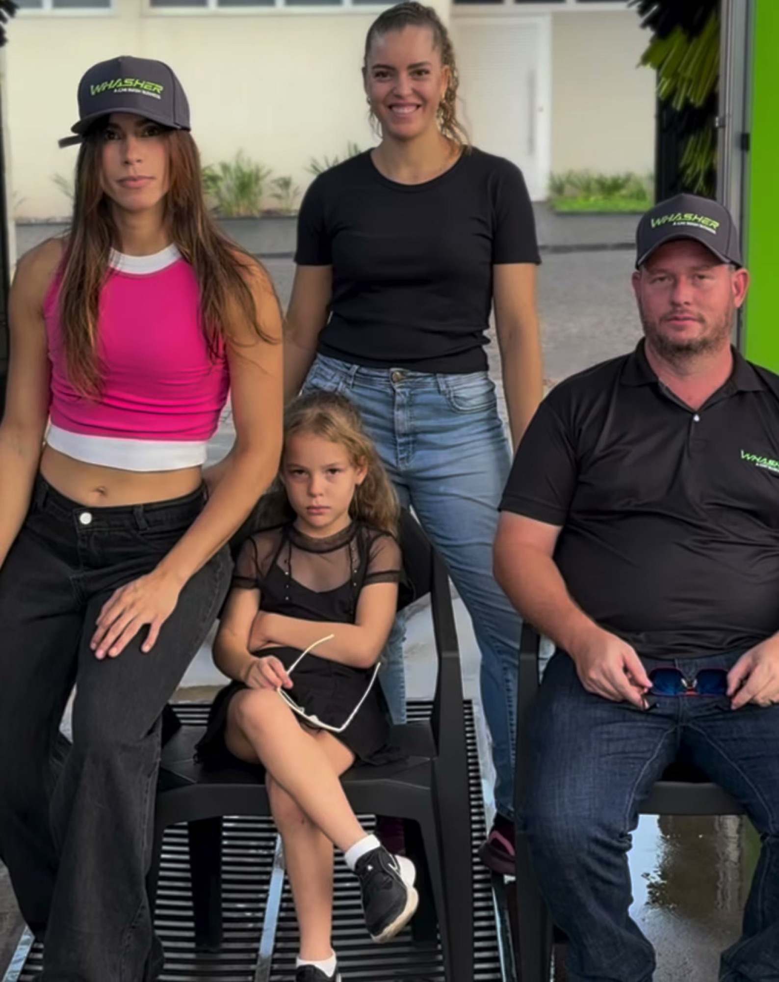 Equipe do Whasher com boné e camisa da marca, na frente da máquina de lavagem