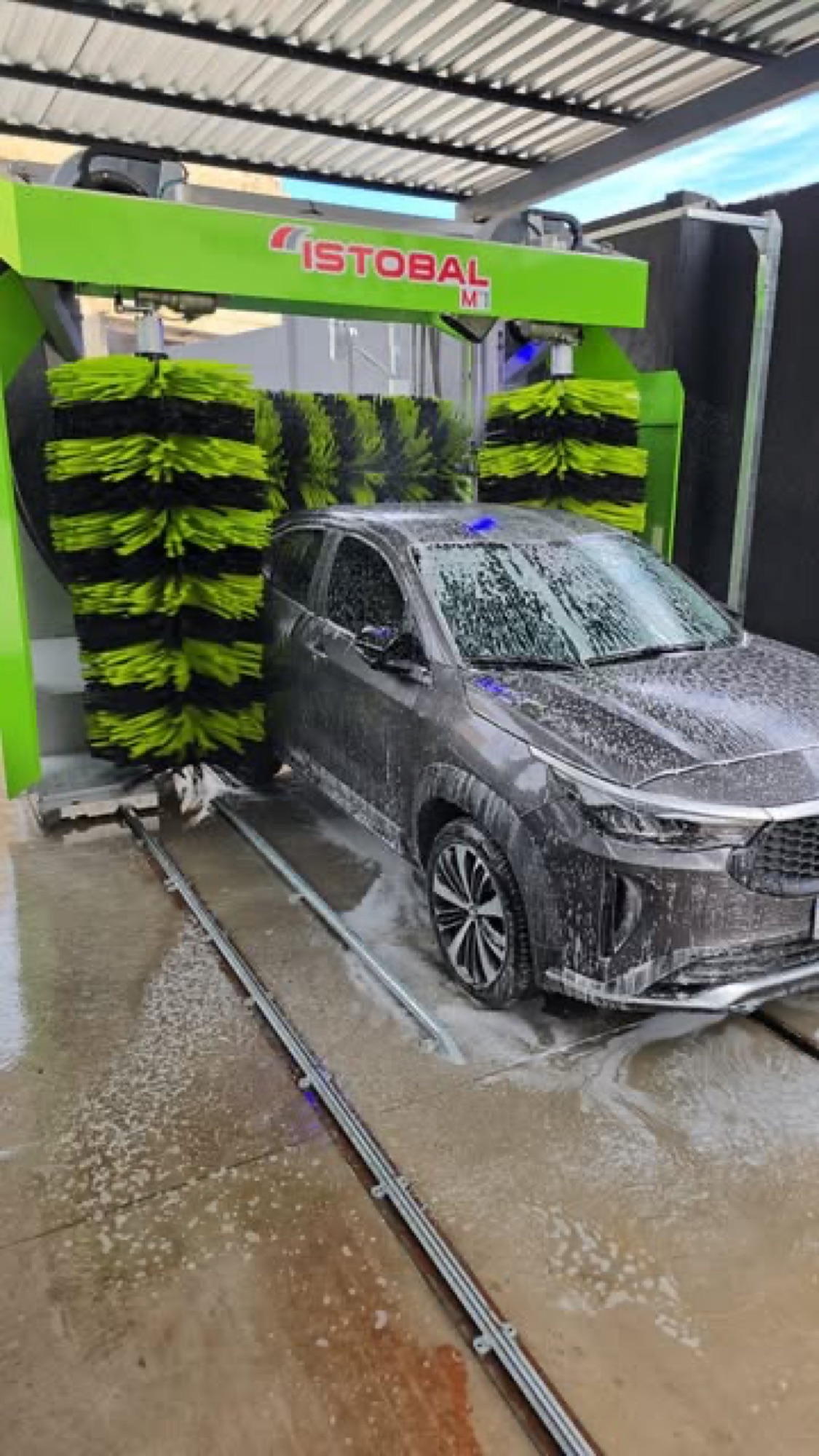 SUV entrando no túnel de lavagem automática do Whasher, com as escovas verdes